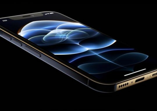 "Un iPhone 12 encendido, destacado contra un fondo negro, con detalles realistas y finas curvas, presentado en un estilo que enfatiza la emoción sobre el realismo, con tonos de índigo y oro."