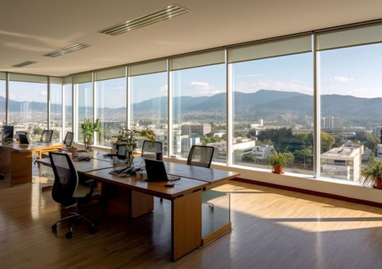 "Oficinas y espacios de trabajo con ventanas que ofrecen vistas panorámicas a las montañas, inspiradas en el estilo del artista Santiago Rusiñol, capturadas desde un ángulo elevado."