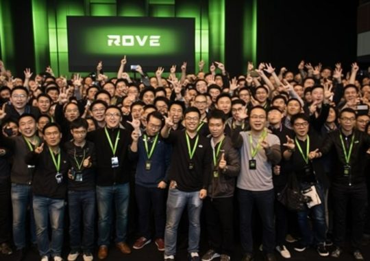 Un grupo de empleados de Rive posando frente a una pantalla verde, en un estilo que recuerda a las escenas detalladas de multitudes, con rayos de luz divina y elementos de neo-academismo y pinceladas chinas.